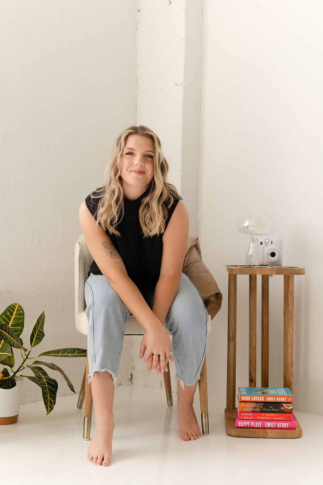 Kaili, conversion copywriter, sitting on a stool and smiling at a camera